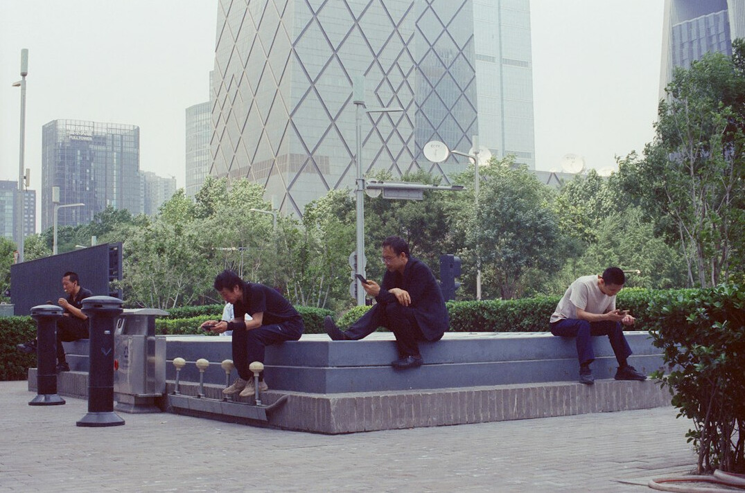 Group of friends laughing together on a public plaza bench