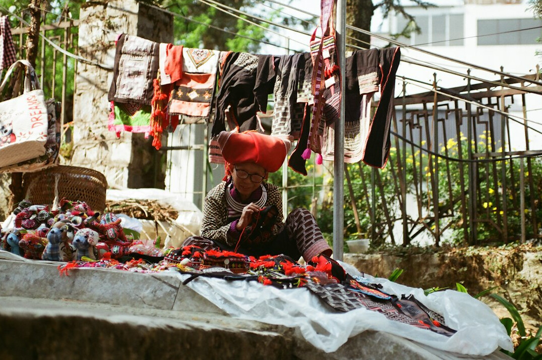 elderly woman knitting in market